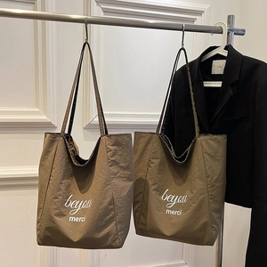 Brown leopard print tote bag with merci typography hanging in a fashion studio setting