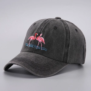 Close-up of pink flamingo embroidery on dark gray washed denim cotton baseball cap