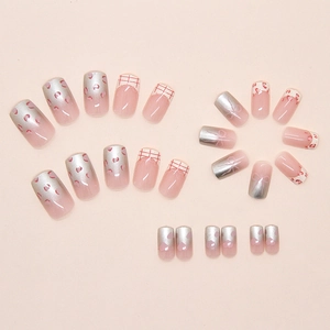 Detail of pink leopard print press-on nails with red heart and bow-knot patterns
