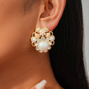 Detail of vintage gold flower earring with pearls and diamonds on a model's ear