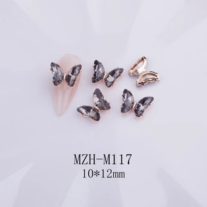 Detalle de dijes para uñas de mariposa de cristal 3D gris moka con bordes de oro rosa