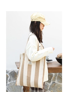 Close-up of brown and white striped canvas tote bag with SEASON 12 brand label