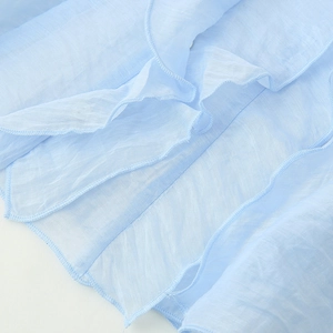 Light blue sleeveless chiffon shirt with ruffled edges and lightweight flowing texture