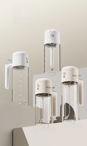Détail de distributeurs d'huile en verre gradué blanc et crème avec poignée ergonomique