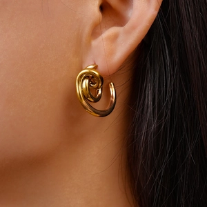 Close-up of 18k gold plated twisted knot C-shape earring worn on a model's ear