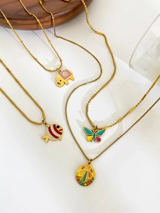 Detailed macro view of colorful enamel animal pendants on gold stainless steel necklaces