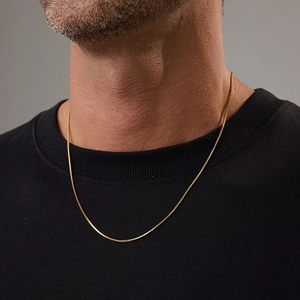 Close-up of gold 18K plated stainless steel snake chain necklace on a male model