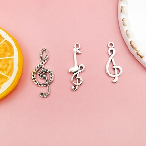 Three silver music note pendants featuring treble clef and eighth note for DIY jewelry
