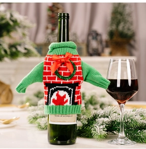 Detail of green knitted Christmas sweater wine bottle cover with wreath and bow