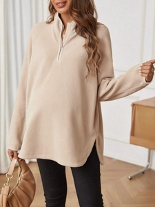 Detail of loose-fit maternity fleece sweatshirt with zipper collar and side slits