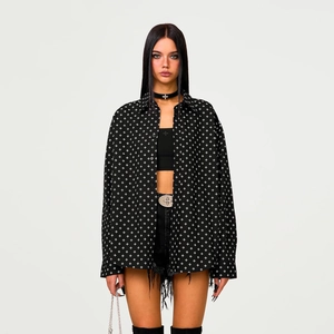 Black cotton shirt with white cross print worn over black top and denim shorts