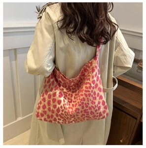 Detail of pink leopard print canvas shoulder bag worn with a stylish trench coat