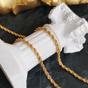 Chic 18K gold plated stainless steel twist chain necklace on white marble pillar