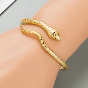 Close-up of golden adjustable snake bracelet featuring detailed engraved scales and head