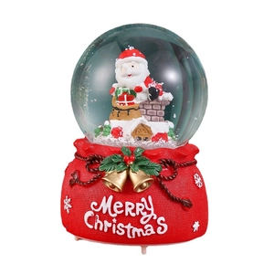 Christmas snow globe with Santa and chimney scene on red festive bag-shaped resin base