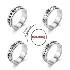 Detail of four silver spinning fidget rings featuring daisy and celestial star moon patterns