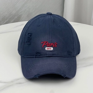 Detailed view of vintage navy baseball cap with red Paris 1976 embroidery and distressed edges
