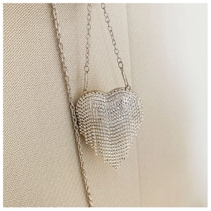 Detailed macro view of heart-shaped silver evening clutch with sparkling rhinestones