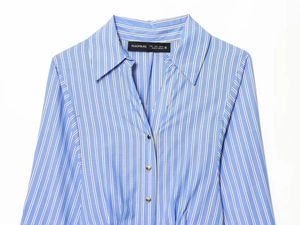 Detailed close-up of blue and white striped shirt collar with gold button accents