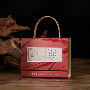 Close-up of red Chinese wedding candy box with leather handle on wooden background