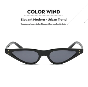 Close-up of black triangle cat-eye sunglasses with gold metal rivets and dark lenses