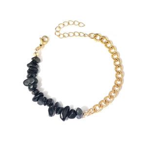 Détail du bracelet en acier doré avec des pierres naturelles noires et une chaîne