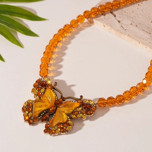 Detail of vintage amber butterfly necklace with crystal rhinestones and beaded chain