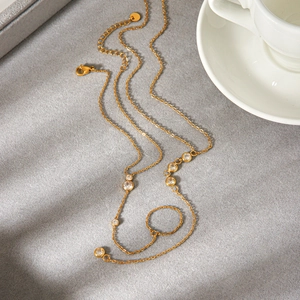 Elegante collana a Y dorata con pietre in zircone trasparente su tessuto grigio morbido
