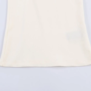 Close-up of cream white knit fabric with vertical texture and flat bottom hem finish