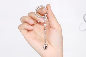 Close-up of hand holding a silver stainless steel keychain with heart pendant and chain link