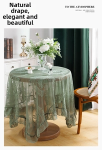 Detailed view of floral embroidery and ruffled edge on a sage green lace tablecloth