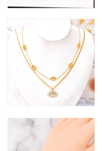 Detail of layered gold evil eye necklace with crystals on white neck mannequin