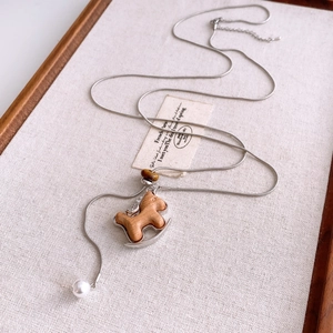 Detail of wooden horse pendant with silver frame and pearl bead on necklace
