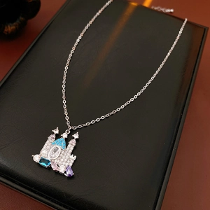 Dettaglio collana con ciondolo a castello in argento e gemme colorate su scatola nera