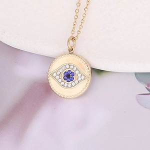 Macro shot of gold stainless steel necklace with blue devil eye crystal pavé pendant
