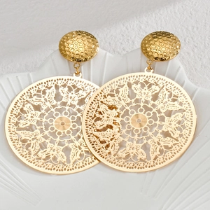 Vintage hollow butterfly pattern gold round earrings on a white shell tray