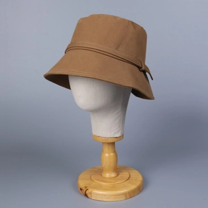 Detailed view of caramel cotton bucket hat with decorative strap on display stand