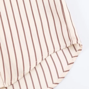 Detalle del dobladillo curvado y el tejido a rayas con costuras precisas en la camisa