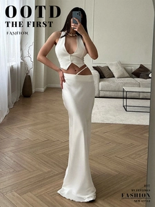 Détail d'une jupe longue en soie blanche taille haute et d'un gilet licou à col en V