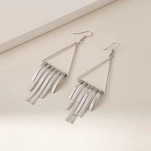 Detailed view of silver geometric triangle drop earrings with long metallic tassels