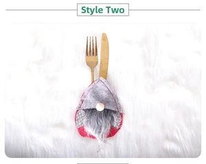 Close-up of a festive gnome cutlery holder on white plush background for Christmas dining
