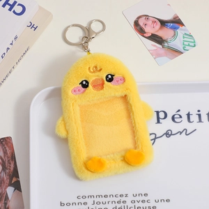 Detail of yellow plush chick photocard holder on decorative tray with book background