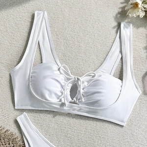 Detailed flat lay of white nylon bikini top with ruched texture and center tie detail