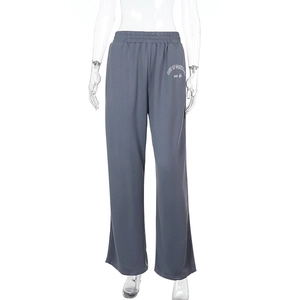 Détail du pantalon de jogging bleu gris avec taille élastique et logo blanc sur la jambe