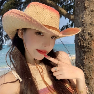 Detail of woven straw cowboy hat with orange gradient brim and adjustable chin strap