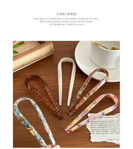 Detailed view of U-shaped acetate hairpins in marble and tortoiseshell patterns