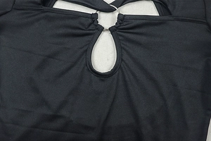 Détail de la découpe avec anneau métallique argenté sur ce body noir moulant de sport