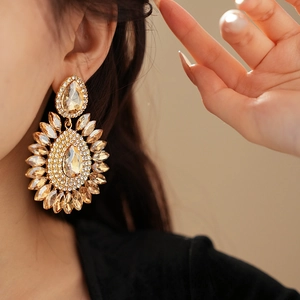 Macro shot of gold teardrop crystal earrings featuring radiant champagne-toned stones