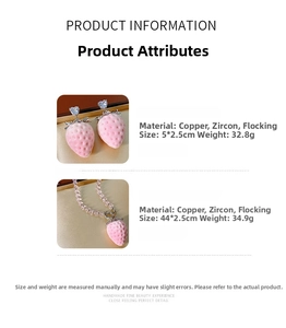 Detailed spec view of pink strawberry drop earrings and necklace with copper and zircon