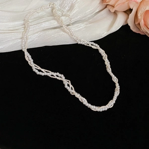 Detail of multi-layer pearl necklace with silver chains on elegant black velvet background